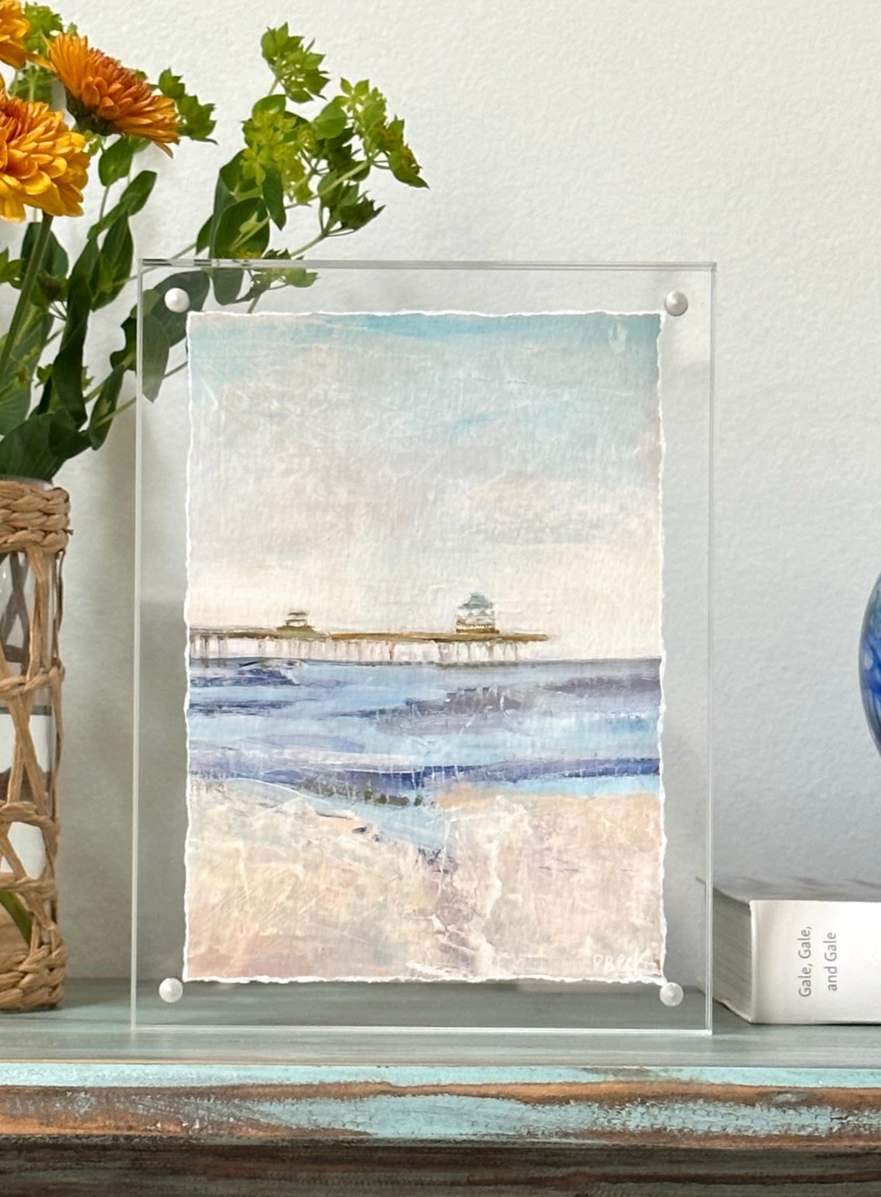 Giclée print of Old Pier on Folly Beach by Charleston artist Ryan Beck, featuring the iconic pier in coastal blues and neutrals, evoking the serene charm of a vintage beach day.